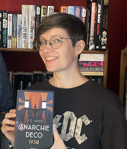 Die Autorin Judith Vogt mit ihrem Roman „Anarchie Déco“. Bild: © privat
